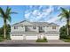 Three-unit building with light gray siding, three garages, and a paved driveway at 31895 Anchor Point Dr, Wesley Chapel, FL 33545
