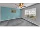 Bedroom with gray carpet, ceiling fan, and large window with blinds at 2857 Brewster Rd, North Port, FL 34288