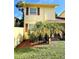 Two-story yellow house with a landscaped yard and palm tree at 7514 Bolanos Ct, Tampa, FL 33615