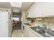 Condo kitchen with white cabinets, a double sink, and a view into the living room at 12760 Indian Rocks Rd # 1071, Largo, FL 33774