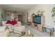 Comfortable living room with light beige couch, ottoman, and large TV at 12760 Indian Rocks Rd # 1071, Largo, FL 33774