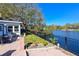 Brick patio with fire pit and seating area near the water at 10931 Clara Ln, St Petersburg, FL 33708