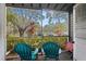 Relaxing screened porch with two teal chairs, overlooking a tree-lined street at 2101 Fox Chase Blvd # 106, Palm Harbor, FL 34683