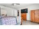 Spacious bedroom with wood flooring, large TV, and ample closet space at 8378 Gibralter St, Spring Hill, FL 34608
