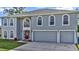 Two-story house with gray siding, red door, and two-car garage at 8378 Gibralter St, Spring Hill, FL 34608