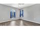 Bedroom with wood-look floors, arched windows, and blue curtains at 8378 Gibralter St, Spring Hill, FL 34608