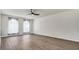 Spacious living room with large windows, wood-look flooring, and a ceiling fan at 8378 Gibralter St, Spring Hill, FL 34608