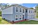 Two-story house with gray and white siding, red door, and three-car garage at 8378 Gibralter St, Spring Hill, FL 34608