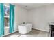 Bathroom with freestanding bathtub and teal curtains at 8378 Gibralter St, Spring Hill, FL 34608