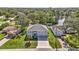 Two-story house with a three-car garage and manicured lawn, located near a lake at 8378 Gibralter St, Spring Hill, FL 34608