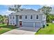 Two-story house with gray siding, three-car garage, and red front door at 8378 Gibralter St, Spring Hill, FL 34608