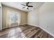 Bright bedroom featuring wood-look flooring and a large window at 10520 Collar Dr, San Antonio, FL 33576