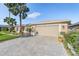 Tan house with a two-car garage and landscaped front yard at 10520 Collar Dr, San Antonio, FL 33576