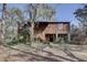 Rustic style two-story home with stairs leading to the front entrance, surrounded by lush trees at 1106 Oxbow Rd, Wimauma, FL 33598