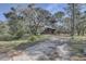 A rustic, two-story home surrounded by mature trees, offering privacy and a natural setting at 1106 Oxbow Rd, Wimauma, FL 33598