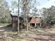 Rustic home with a elevated deck, stairs, mature trees, lush landscaping at 1106 Oxbow Rd, Wimauma, FL 33598