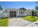 Charming bungalow home with a gray exterior, dark garage door, and paver driveway at 2921 Sanchez St, Tampa, FL 33605