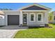 Modern house exterior with gray siding, dark garage door, and a manicured lawn at 2921 Sanchez St, Tampa, FL 33605