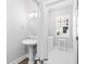 Charming bathroom featuring a pedestal sink, round mirror, and washer/dryer hookups at 5902 Yeats Manor Dr, Tampa, FL 33616