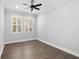 An airy bedroom featuring hardwood floors, modern trim, and bright natural light at 5902 Yeats Manor Dr, Tampa, FL 33616