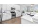 Modern kitchen with stainless steel appliances, white cabinets, quartz countertops, and hardwood flooring for sleek style at 5902 Yeats Manor Dr, Tampa, FL 33616