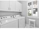 Bright laundry room featuring white washer/dryer, tile floors, and natural light at 5902 Yeats Manor Dr, Tampa, FL 33616