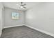 Bright bedroom with gray wood-look floors and a ceiling fan at 8514 Woodwick Ct, Tampa, FL 33615