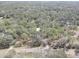 Aerial view showing home nestled in a wooded area with a paved road nearby at 1106 Oxbow Rd, Wimauma, FL 33598