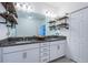 Modern bathroom with granite countertops, double sinks, and industrial-style shelving at 2444 Foggy Creek Cir, Clearwater, FL 33764