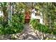 Building entrance with lush landscaping and stone pathway, creating a welcoming atmosphere at 1012 Pearce Dr # 209, Clearwater, FL 33764