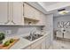 Kitchen with white cabinets, sink, and view to dining area at 1012 Pearce Dr # 209, Clearwater, FL 33764