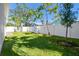 Fenced backyard with a grassy lawn and young trees at 2921 Sanchez St, Tampa, FL 33605