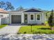 Newly built home with gray exterior, dark gray garage door, and a brick paved driveway at 2921 Sanchez St, Tampa, FL 33605