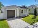 Newly built home with gray exterior, dark gray garage door, and a brick paved driveway at 2921 Sanchez St, Tampa, FL 33605