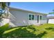 Newly constructed home showcasing a clean gray exterior, a grassy lawn, and a fenced backyard at 2921 Sanchez St, Tampa, FL 33605
