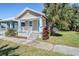 Charming bungalow with teal door, white porch, and landscaped yard at 1325 W North B St, Tampa, FL 33606