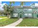 Green two-story townhome with a walkway, palm tree, and well-maintained lawn at 10404 White Lake Ct # 10404, Tampa, FL 33626