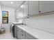 Bright laundry room with gray cabinets and quartz countertops at 5104 W Evelyn Dr, Tampa, FL 33609