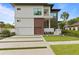 Modern two-story house with a two car garage and lush landscaping at 5104 W Evelyn Dr, Tampa, FL 33609