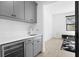 Modern wet bar with gray cabinets and quartz countertops at 5104 W Evelyn Dr, Tampa, FL 33609