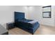 Serene bedroom featuring a blue upholstered bed and wood floors at 5104 W Evelyn Dr, Tampa, FL 33609