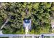 Aerial view of a house nestled among lush trees, showcasing its secluded setting and architectural design at 4586 Hickory Oak Dr, Brooksville, FL 34601