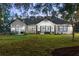 Backyard with patio, large lawn, and mature trees at 4586 Hickory Oak Dr, Brooksville, FL 34601