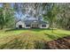 Expansive backyard featuring a covered patio and lush green lawn, offering a serene outdoor living space at 4586 Hickory Oak Dr, Brooksville, FL 34601