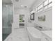 Modern bathroom featuring a glass-enclosed shower, marble tile, standalone tub, and double sink vanity at 4586 Hickory Oak Dr, Brooksville, FL 34601