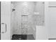 Modern bathroom shower with marble-style tile, dark tile floors, and glass door at 4586 Hickory Oak Dr, Brooksville, FL 34601