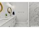Bathroom with double sink vanity, white cabinets, and marble style tile at 4586 Hickory Oak Dr, Brooksville, FL 34601