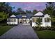 Charming single-story home with a brick driveway, manicured lawn, and classic white facade against a colorful sunset at 4586 Hickory Oak Dr, Brooksville, FL 34601