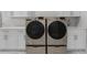 Laundry room with modern washer and dryer, white countertops, and white cabinets at 4586 Hickory Oak Dr, Brooksville, FL 34601