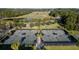 Aerial view of community tennis courts nestled near a lake and golf course at 4586 Hickory Oak Dr, Brooksville, FL 34601